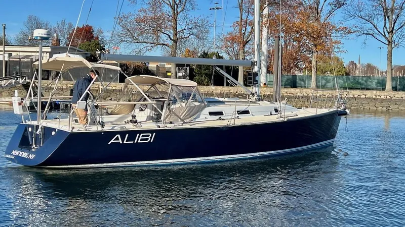 Slide: The Image of 2000 J/120 sailboat on calm water, featuring a blue hull and beige canopy. - 34