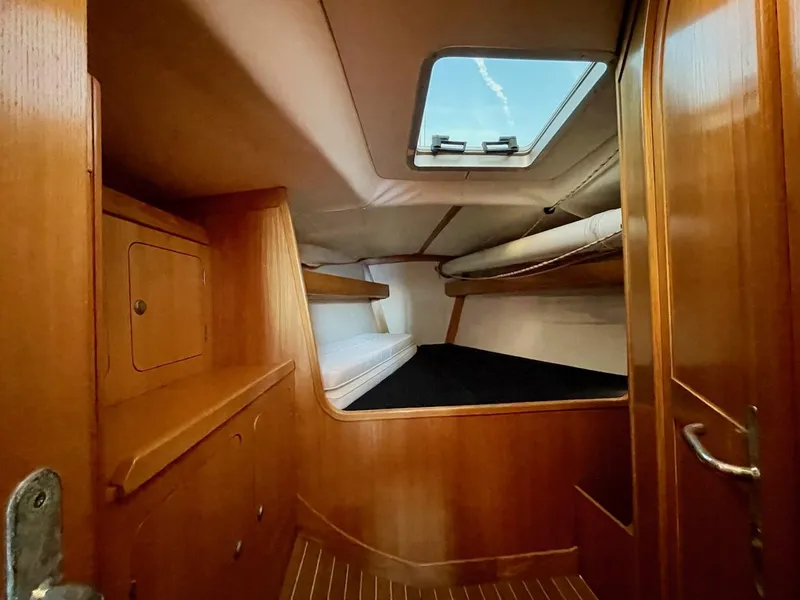 Slide: The Image of The cabin of a 2000 J/120 with wood paneling and a skylight. - 26