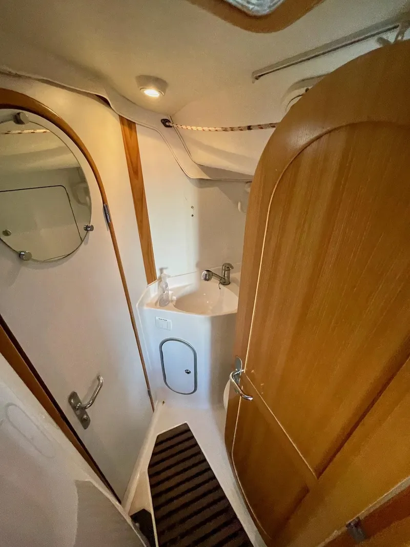 Slide: The Image of The image shows a boat bathroom with wooden doors and a small sink. - 27