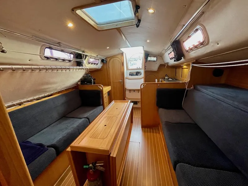 Slide: The Image of Interior of a 2000 J/120 with wooden floors, blue seating, and skylights. - 20