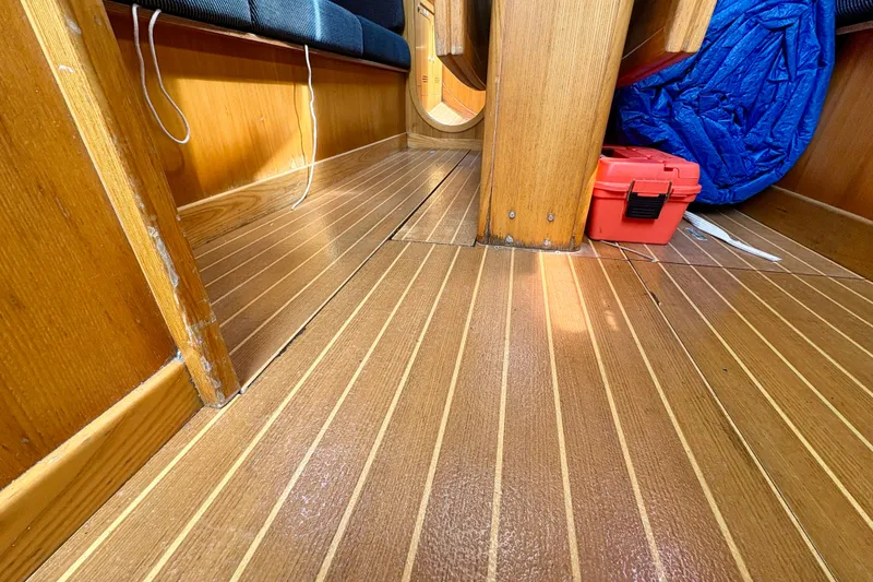 Slide: The Image of Interior of 2000 J Boats J/120 with wooden flooring and red toolbox. - 18