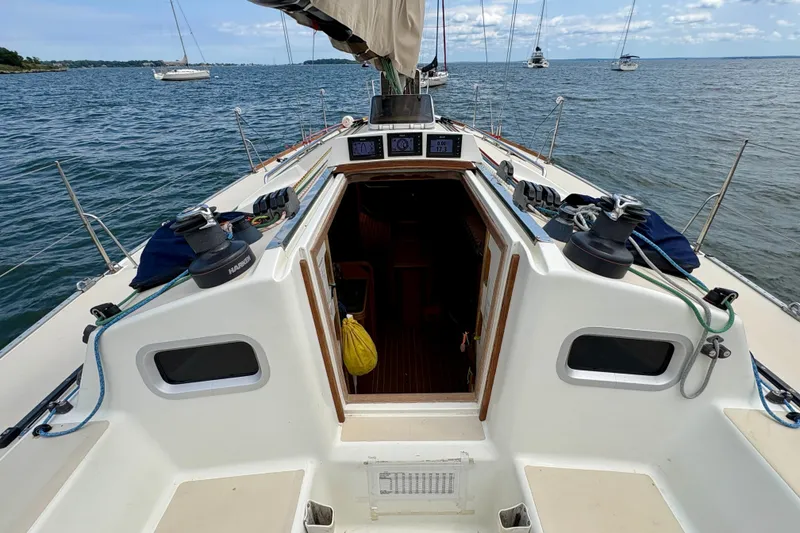 Slide: The Image of 2000 J Boats J/120 sailboat cockpit with winches, ropes, and open cabin entrance. - 4