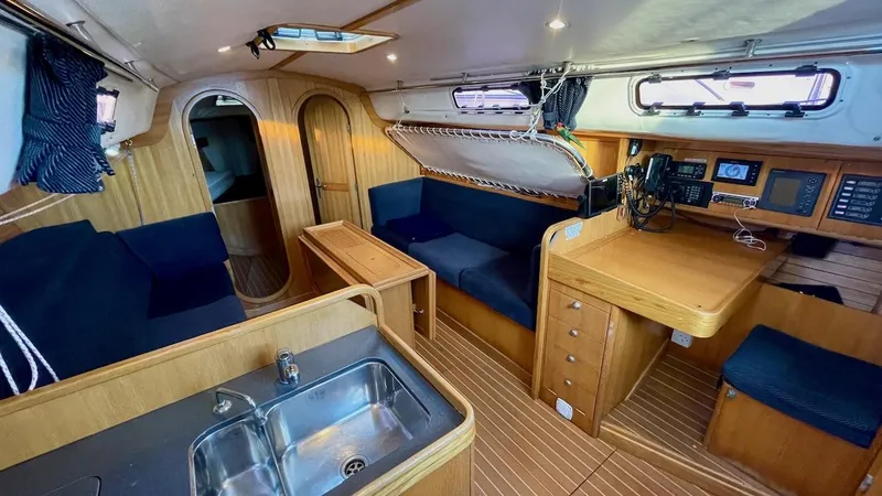 Slide: The Image of Interior of a 2000 J/120 yacht featuring wood finish, galley, and navigation area. - 22