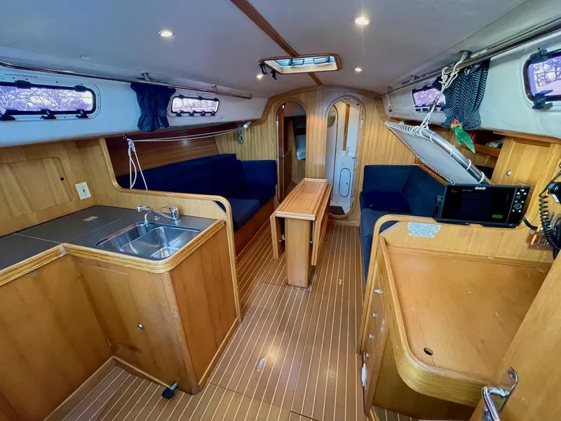 Slide: The Image of Interior of a 2000 J/120 with wooden floors, kitchenette, seating area, and navigation equipment. - 29