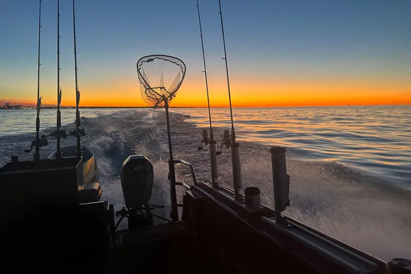 Slide: The Image of Sunset view from a 2022 Extreme Boats 745 Walk Around, with fishing gear on deck. - 11