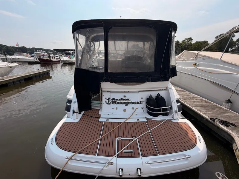 Slide: The Image of A 2005 Doral Intrigue docked. It features a spacious aft deck with a wood-like finish. - 4