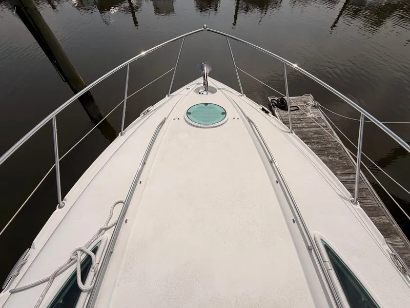 Slide: The Image of The 2005 Doral Intrigue is docked in calm waters. The foredeck is clean and well-maintained. - 7