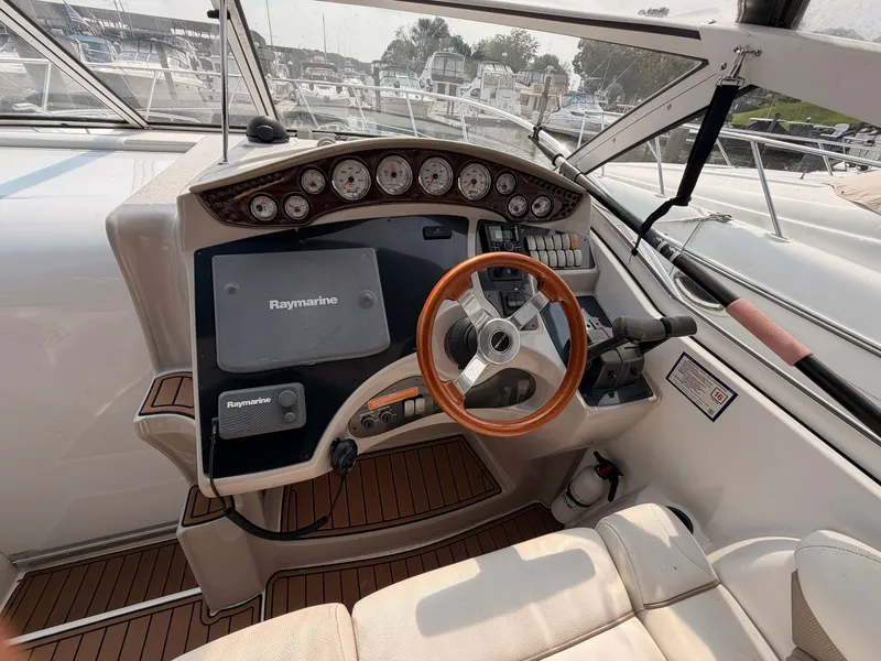 Slide: The Image of The image shows the cockpit of a 2005 Doral Intrigue with a wooden steering wheel and Raymarine electronics. - 10