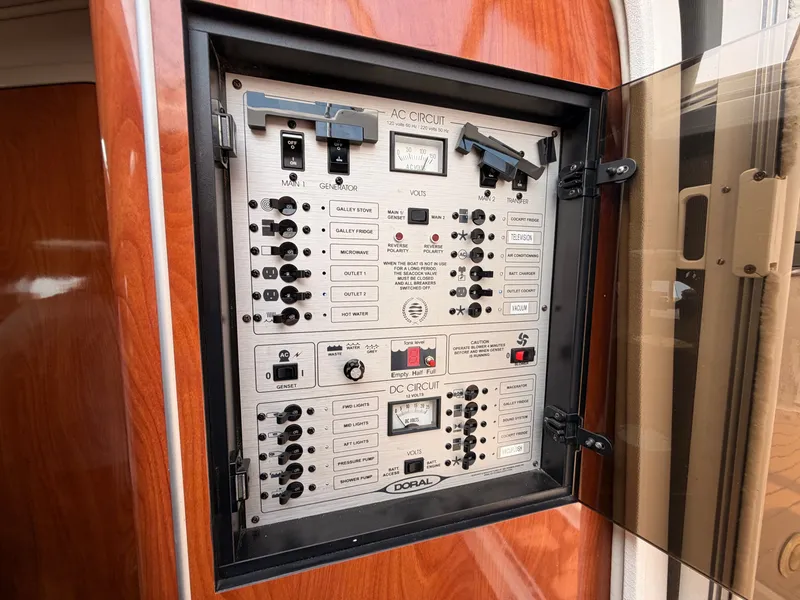 Slide: The Image of An electrical panel on a 2005 Doral Intrigue boat, featuring various switches and gauges. - 35