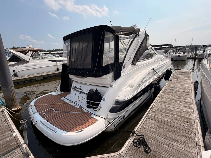 Slide: The Image of A 2005 Doral Intrigue docked at a wooden pier. Other boats are visible in the background. - 3