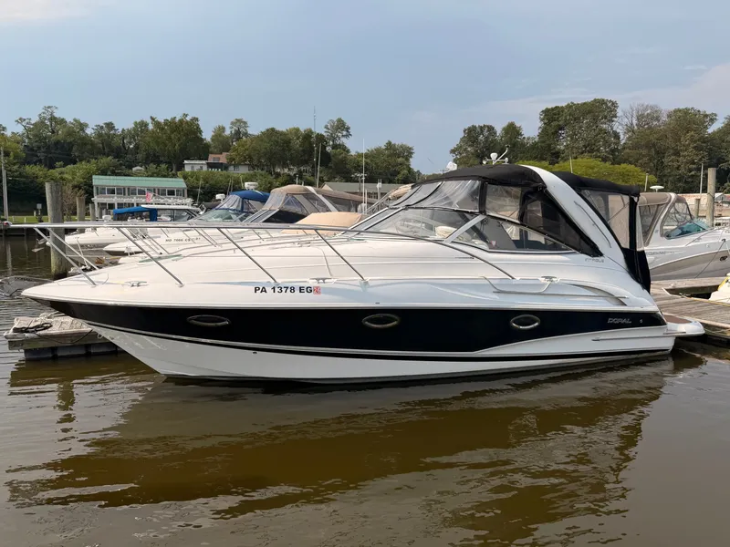 Slide: The Image of A 2005 Doral Intrigue docked. It features a sleek design with a black and white hull. - 2