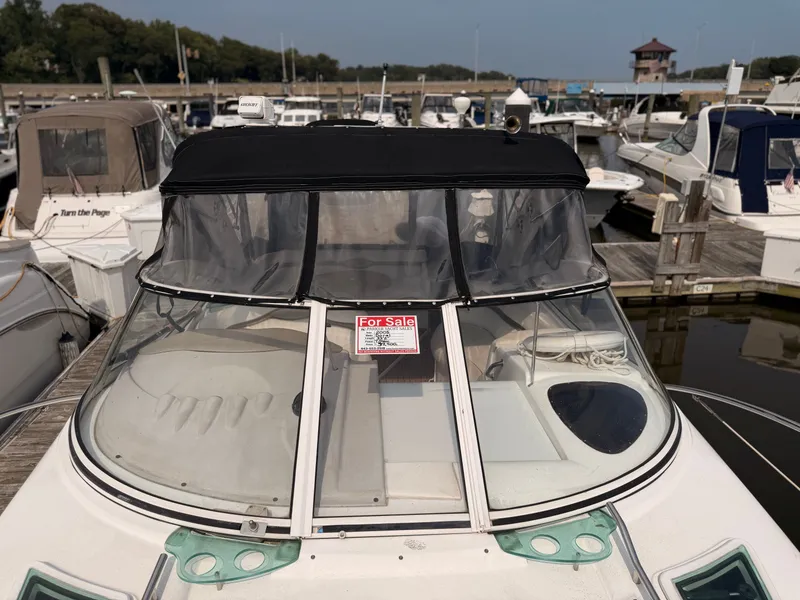 Slide: The Image of A 2005 Doral Intrigue boat docked in a marina. It features a black canopy and a 'For Sale' sign. - 37