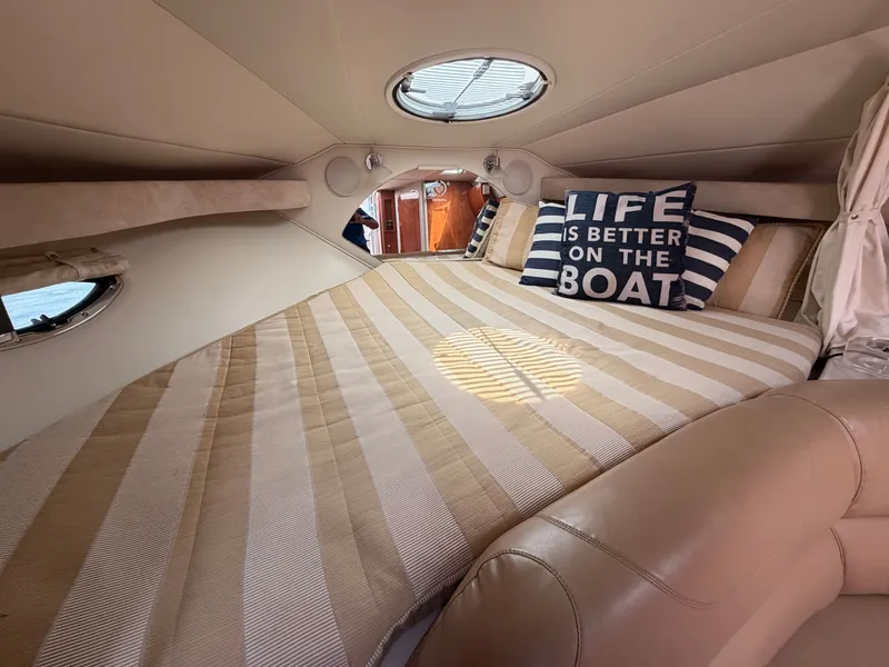Slide: The Image of The interior of a 2005 Doral Intrigue features a cozy bed with striped bedding and a decorative pillow. - 27