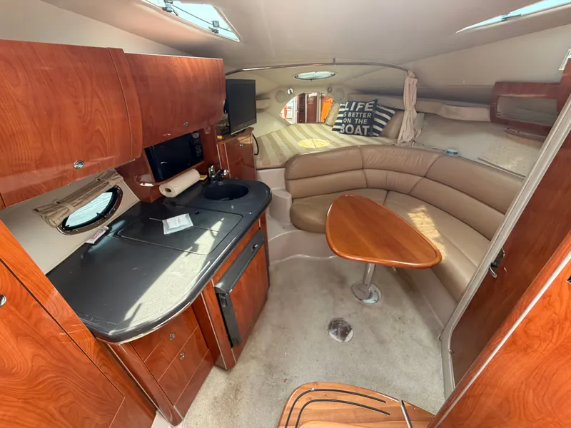 Slide: The Image of Interior of a 2005 Doral Intrigue with wood cabinetry, kitchenette, and seating area. - 21