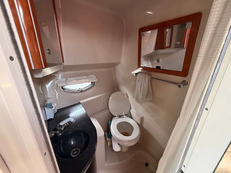 Slide: The Image of The image shows a boat bathroom with a toilet, sink, and mirror. - 29