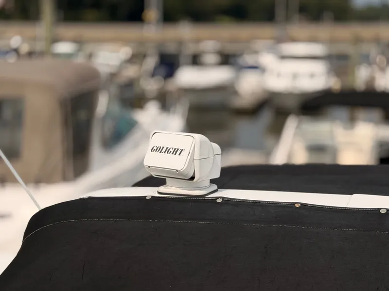 Slide: The Image of A Golight spotlight is mounted on a black boat cover, with blurred boats in the background. - 38
