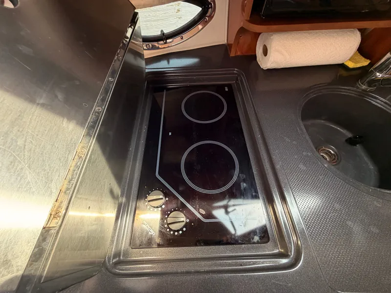 Slide: The Image of The galley of a 2005 Doral Intrigue with a modern cooktop and sink. - 24