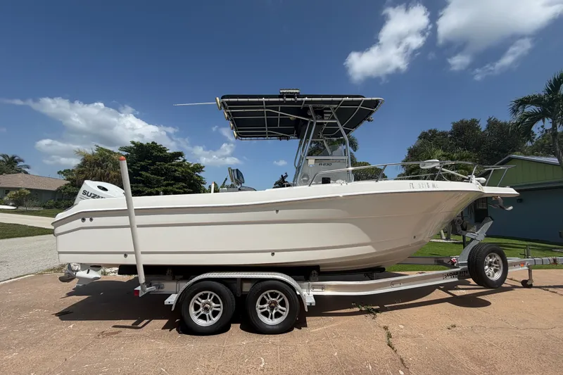 Slide: The Image of 2003 Robalo R230 Center Console boat on trailer, sunny day, residential background. - 9