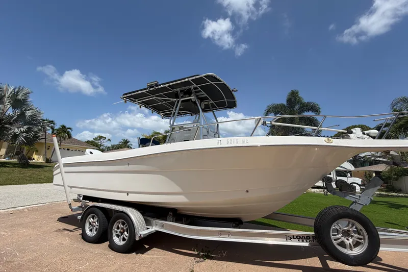 Slide: The Image of 2003 Robalo R230 Center Console boat on trailer, sunny day, palm trees in background. - 3