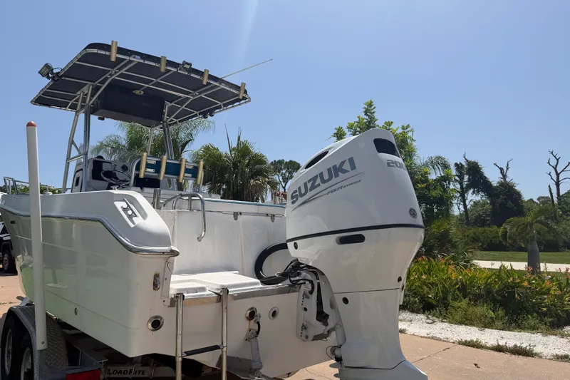 Slide: The Image of 2003 Robalo R230 Center Console boat with Suzuki outboard motor, parked on a trailer. - 1