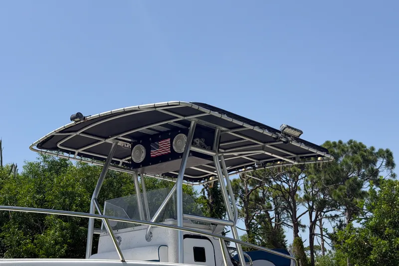 Slide: The Image of 2003 Robalo R230 Center Console boat with T-top and American flag detail. - 8
