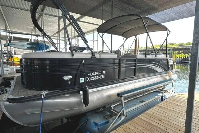 Slide: The Image of 2019 Harris Sunliner 240 pontoon boat docked under a covered marina. - 3