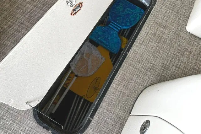Slide: The Image of Storage compartment in a 2019 Harris Sunliner 240 boat, containing various boating accessories. - 28