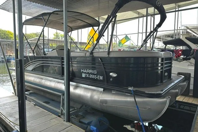 Slide: The Image of 2019 Harris Sunliner 240 pontoon boat docked in a marina. - 2