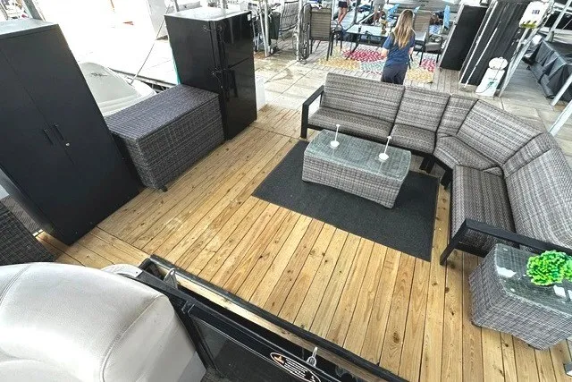 Slide: The Image of 2019 Harris Sunliner 240 boat interior with wooden deck, wicker furniture, and modern decor. - 38