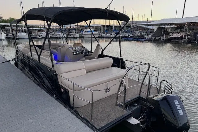 Slide: The Image of 2019 Harris Sunliner 240 pontoon boat docked at marina, featuring spacious seating and canopy. - 1