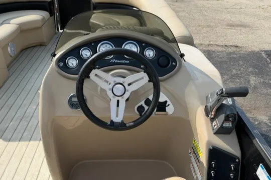 Slide: The Image of 2017 Manitou 22 Oasis Standard boat dashboard with steering wheel and control panel. - 12