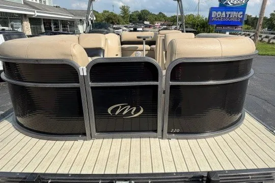 Slide: The Image of 2017 Manitou 22 Oasis Standard pontoon boat with beige seating and black exterior. - 2