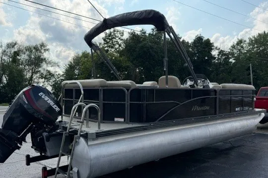 Slide: The Image of 2017 Manitou 22 Oasis Standard pontoon boat with Evinrude outboard motor, parked outdoors. - 5