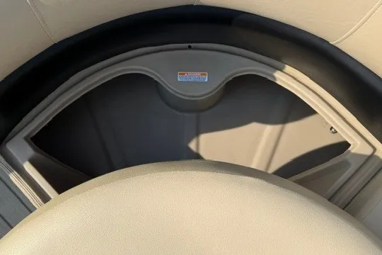 Slide: The Image of 2017 Manitou 22 Oasis Standard boat storage compartment, beige interior detail. - 21