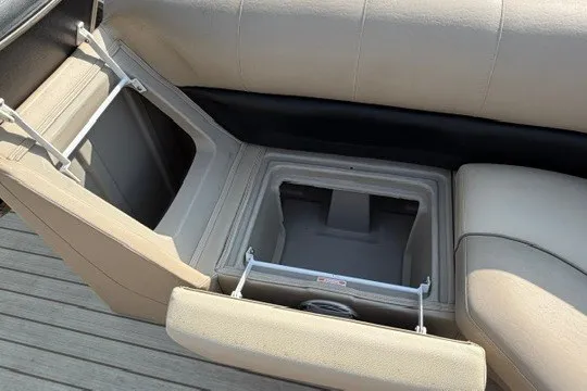 Slide: The Image of 2017 Manitou 22 Oasis Standard boat seat storage compartment open on deck. - 26