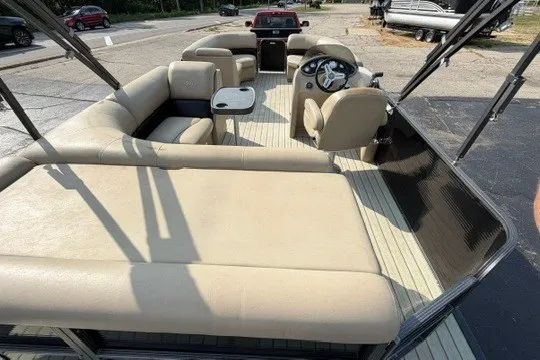 Slide: The Image of 2017 Manitou 22 Oasis Standard pontoon boat with beige seating and steering console. - 10