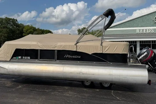 Slide: The Image of 2017 Manitou 22 Oasis Standard pontoon boat with cover, parked outdoors near a building. - 38