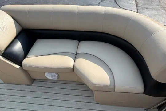 Slide: The Image of 2017 Manitou 22 Oasis Standard boat seating, beige and black upholstery, curved design. - 23