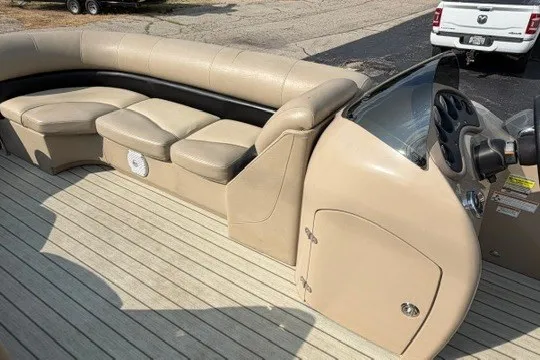 Slide: The Image of 2017 Manitou 22 Oasis Standard pontoon boat interior with beige seating and steering console. - 18