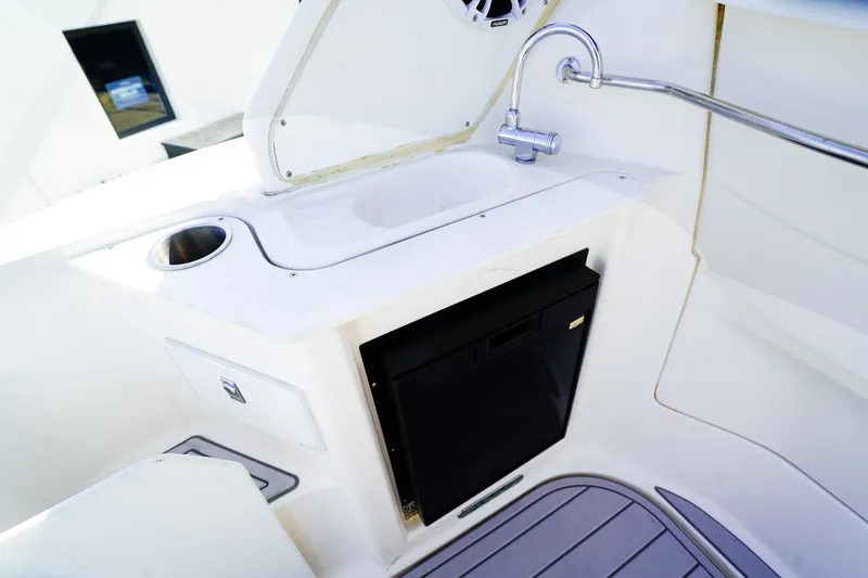 Slide: The Image of 2004 Regal Commodore 2860 boat interior with sink, faucet, and mini fridge. - 7