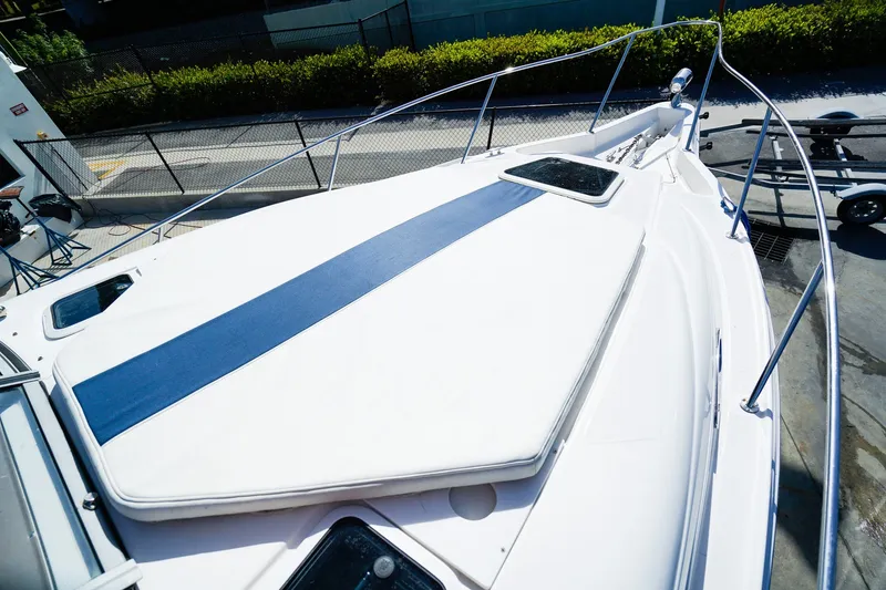 Slide: The Image of 2004 Regal Commodore 2860 boat deck with blue sunpad, docked outdoors. - 28