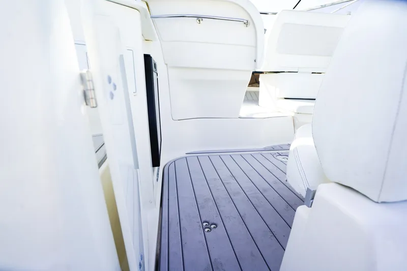 Slide: The Image of Interior view of 2004 Regal Commodore 2860 boat, featuring sleek white seating and flooring. - 5