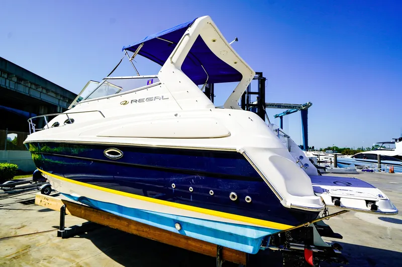 Slide: The Image of 2004 Regal Commodore 2860 boat on display at a marina under clear blue skies. - 2