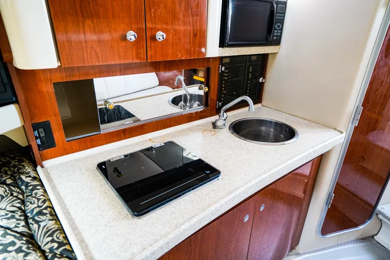 Slide: The Image of 2004 Regal Commodore 2860 boat kitchen with sink, stove, and microwave. - 19