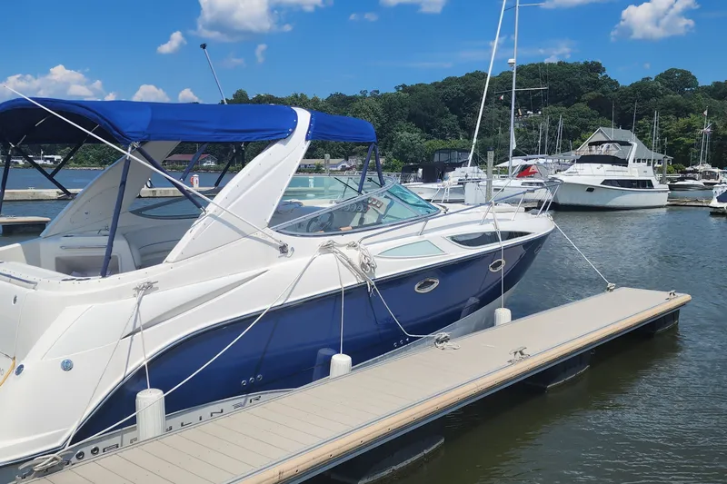 The Image of 2008 Bayliner 300 boat docked at marina under blue sky. - 0