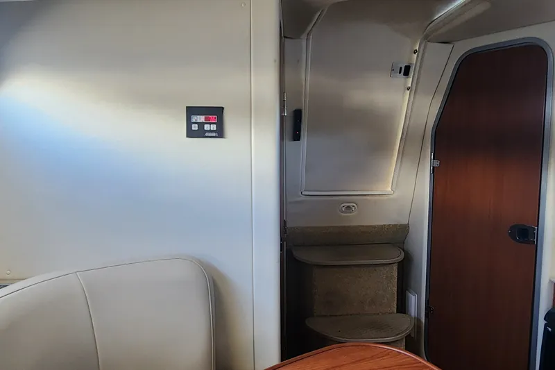 Slide: The Image of Interior of a 2008 Bayliner 300 boat, featuring a control panel and wooden door. - 17