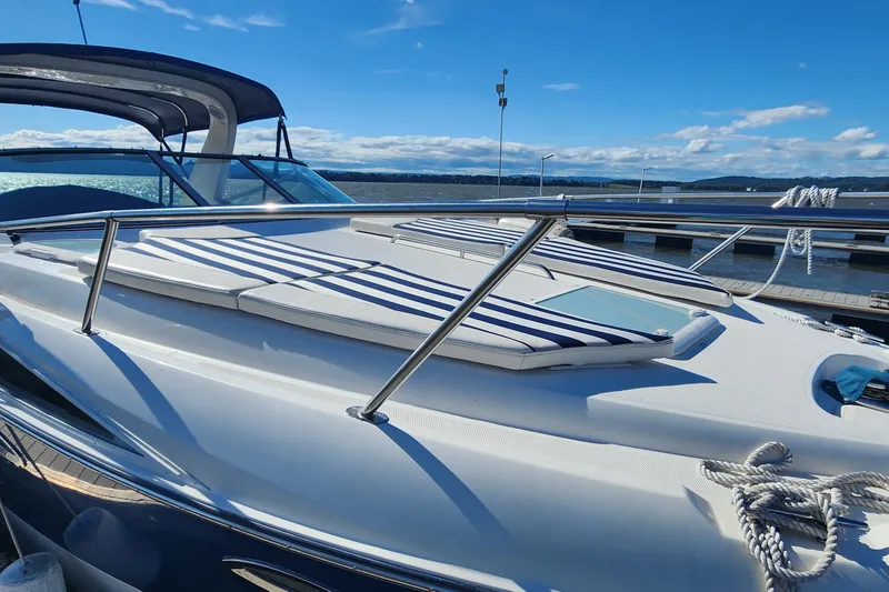 Slide: The Image of 2008 Bayliner 300 boat with striped cushions, docked under a clear blue sky. - 4