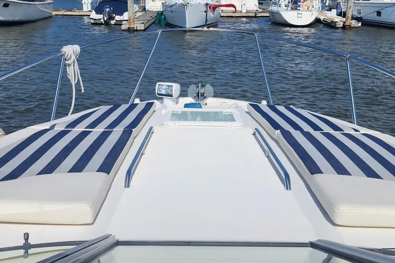 Slide: The Image of 2008 Bayliner 300 boat with striped sun pads docked at marina. - 5