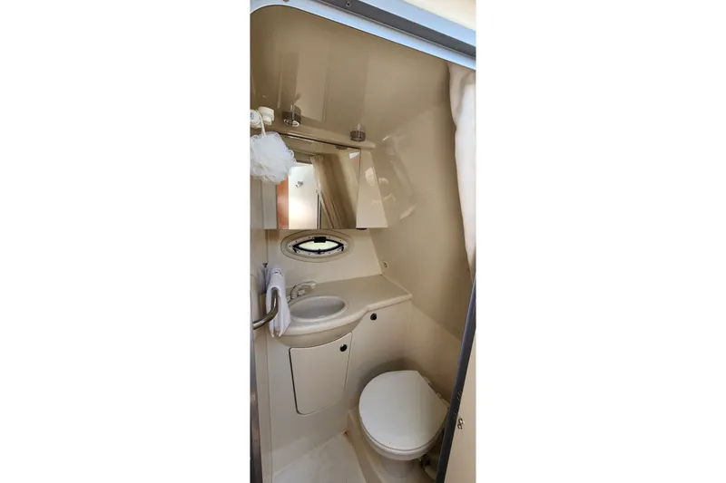 Slide: The Image of Compact bathroom in 2008 Bayliner 300 boat, featuring sink, toilet, and mirror. - 16