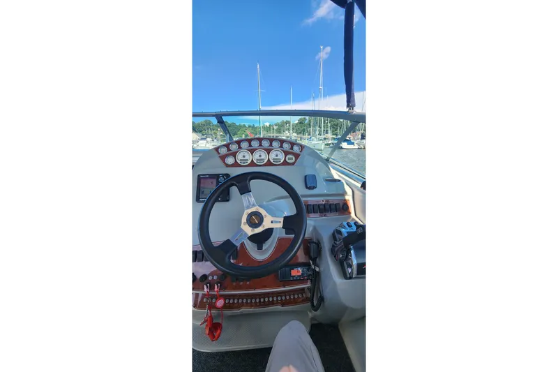 Slide: The Image of Cockpit view of a 2008 Bayliner 300 boat with steering wheel and gauges. - 7
